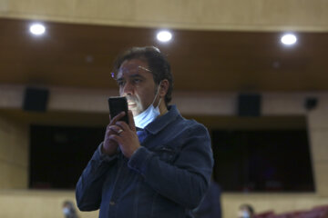 یک خبرنگار در نشست رسانه ای فیلم «۲۸۸۸» با تلفن همراه خود صحبت می کند