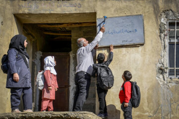 اقای اسعدیان و دانش آموزان مدرسه آزادی تابلوی مدرسه را نصب می کنند.