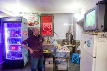 A Tabriz, les commerçants regardent le match Iran-Angleterre au travail  