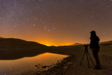 طلوع صورت فلکی شکارچی و عکاس آسمان شب که در حال عکاسی از این نما است 
