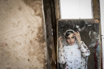 عروس لَچک خود را در آئینه بررسی می کند.