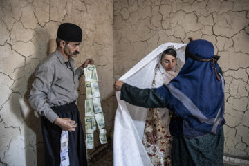 پدر عروس به همراه یکی از زنانِ فامیل، عروس را برای رفتن به خانه بخت آماده می کند. آن ها مبلغی ازهدایایی را که اقوام به خانواده عروس پیشکش کرده اند را طبق رسم ، روی سرِ عروس سنجاق می کنند.این رسم نشانه رزق و روزی برای عروس و داماد است.