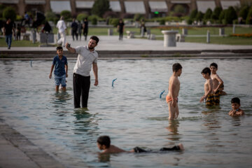 Niños isfahaníes se refrescan este verano en la plaza de Naqsh-e Yahan