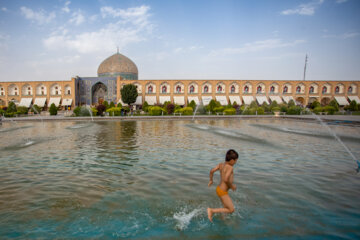 Niños isfahaníes se refrescan este verano en la plaza de Naqsh-e Yahan