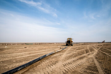 بیل مکانیکی در حال انتقال لوله های تخلیه آب ورودی به داکت ها در ابتدای کانال