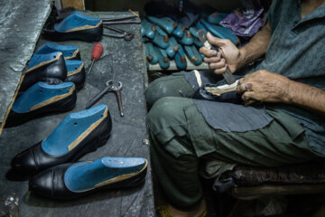 مرحله زیر سازی کفش توسط یکی از کارگران انجام می شود. 
