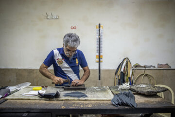 نادر حاصلی ۳۰ است به کار تولید کفش مشغول است. او مرحله پسایی سازی را انجام می دهد.