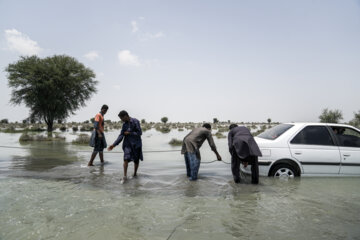خودرو های سواری که در مسیر سیلاب سند میرثعبان گیر کرده اند توسط اهالی کمک رسانی می‌شوند.