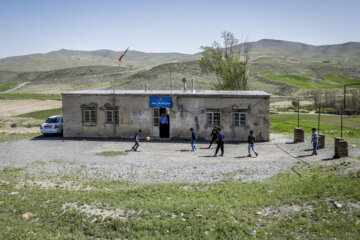 دانش آموزان مدرسه بیاتان سوخته زنگ تفریح در محوطه مدرسه فوتبال بازی می‌کنند.