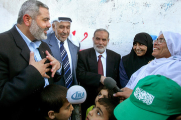 اسماعیل هنیه، نخست وزیر منتخب حماس، پس از تصویب کابینه وی توسط پارلمان فلسطین در غزه در ۲۸ مارس ۲۰۰۶، با خانواده شیخ احمد یاسین، رهبر فقید حماس، گفتگو می کند. عکس: رویترز/صهیب سالم