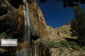 Tourists visiting cool waterfall in central Iran