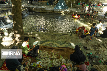 Tourists visiting cool waterfall in central Iran