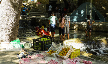 Tourists visiting cool waterfall in central Iran