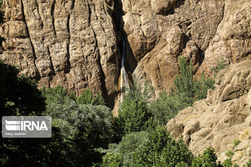 Tourists visiting cool waterfall in central Iran