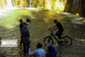 Tourists visiting cool waterfall in central Iran