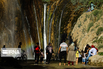 Tourists visiting cool waterfall in central Iran