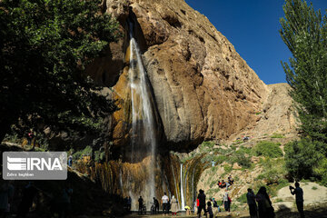 Tourists visiting cool waterfall in central Iran