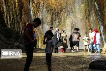 Tourists visiting cool waterfall in central Iran