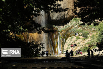 Tourists visiting cool waterfall in central Iran