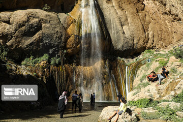 Tourists visiting cool waterfall in central Iran