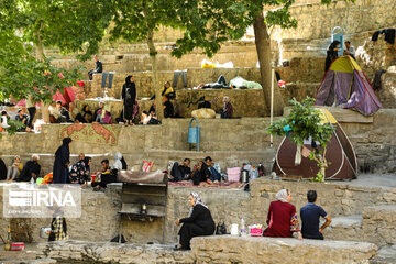 Tourists visiting cool waterfall in central Iran