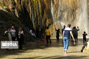 Tourists visiting cool waterfall in central Iran