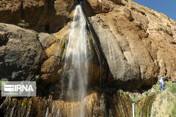 Tourists visiting cool waterfall in central Iran