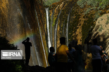 Tourists visiting cool waterfall in central Iran