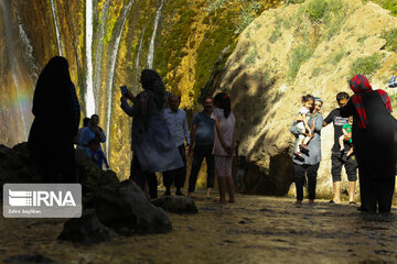 Tourists visiting cool waterfall in central Iran