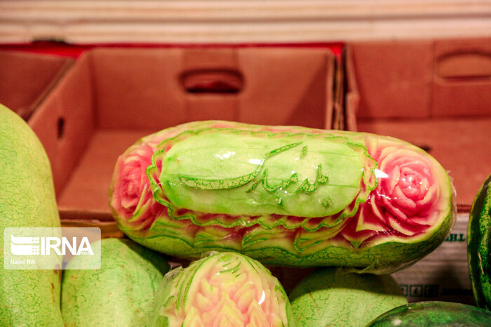 A fruit shop has decorated a watermelon. The writing reads: Happy Yalda