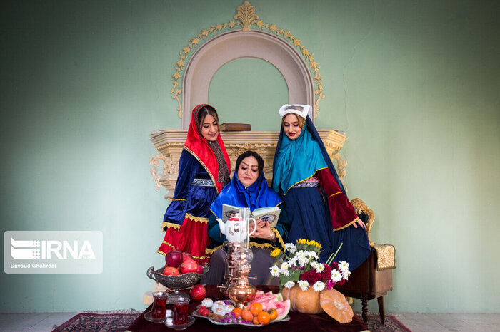 A table decorated in a traditional style with women in traditional dressing.