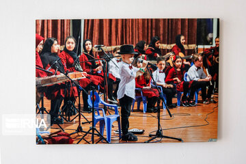 Amir Reza singing with a group of children during his illness. This photo is hung on the wall of his room.