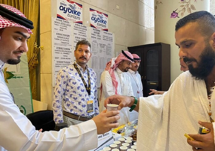 استقبال میزبان از میهمانان خانه خدا با گل و آب زمزم