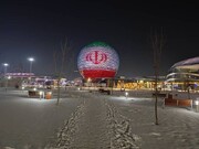 Kazakh spherical building lit with Iran flag colors