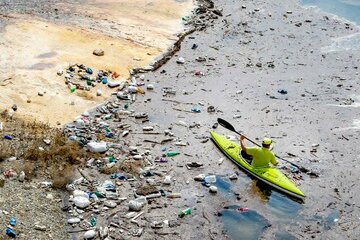 دوستدار محیط‌ زیست زباله‌های شناور در دریاچه سد مهاباد را جمع‌ کرد