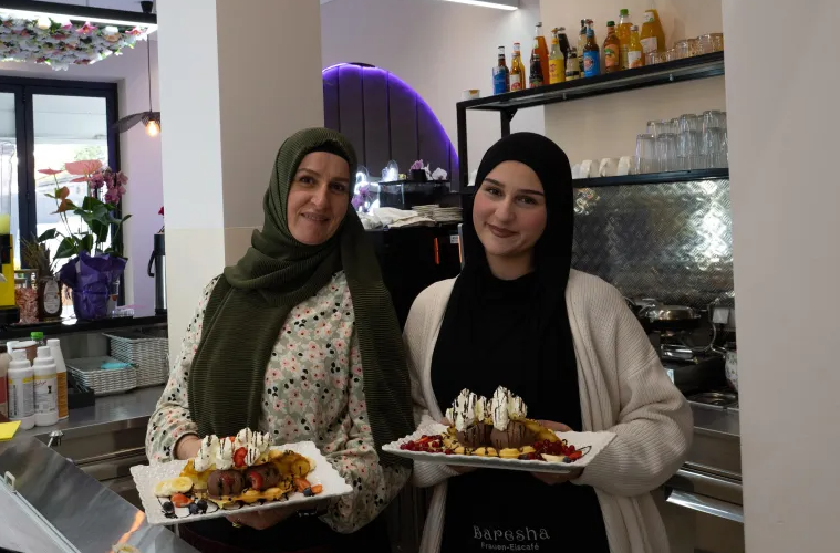 سومیا زامبیری (راست) و مادرش هرمیت زامبیری در کافهای که اخیراً افتتاح کرده است کار میکنند